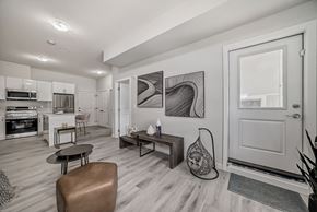 Edmonton apartment for rent - a living room with a door to a kitchen and a dining room