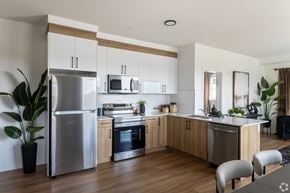 Edmonton apartment for rent - A modern kitchen with wooden cabinets and stainless steel appliances.at The Pointe at Riverview, Edmonton, AB T6M 3H4