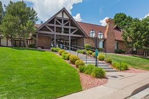 Colorado Springs apartment for rent - A building with a red roof and a green lawn in front.