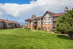 Colorado Springs apartment for rent - A large building with a green lawn in front.