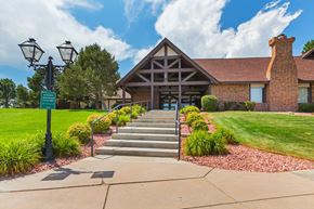 Colorado Springs apartment for rent - A building with a red brick chimney and a green sign in front of it.