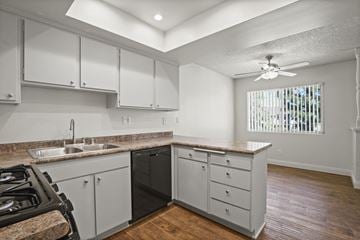 Anaheim apartment for rent - A kitchen with a black stove top oven and white cabinets.