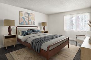 Anaheim apartment for rent - A bedroom with a bed, two lamps, and a painting on the wall.