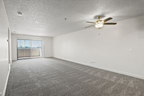 Anaheim apartment for rent - A spacious room with a ceiling fan and carpeted floor.