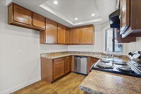 Anaheim apartment for rent - A kitchen with wooden cabinets and a granite countertop.