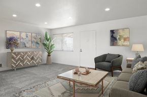 Santa Ana apartment for rent - A living room with a grey couch, a wooden coffee table, and a rug.
