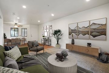 Anaheim apartment for rent - A living room with a green couch, a coffee table, and a painting on the wall.