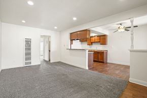Anaheim apartment for rent - A spacious room with a grey carpet and wooden floors.