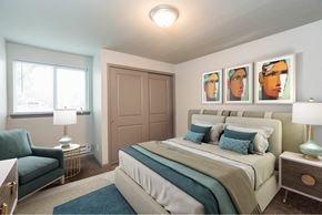 Colorado Springs apartment for rent - A bedroom with a bed, a chair, and a painting on the wall.