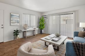 Anaheim apartment for rent - A living room with a white couch, a coffee table, and a potted plant.