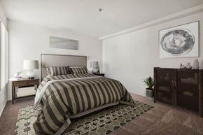 Anaheim apartment for rent - A bedroom with a large bed and a painting on the wall.
