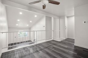 Anaheim apartment for rent - A spacious room with a ceiling fan and wooden flooring.