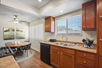 Anaheim apartment for rent - A kitchen with wooden cabinets and a black trash can.
