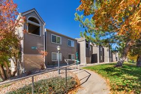 Littleton apartment for rent - A building with the number 5915 on it is surrounded by trees with orange leaves.
