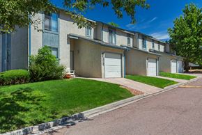 Colorado Springs apartment for rent - A row of apartment buildings with green lawns in front.