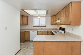 Colorado Springs apartment for rent - A kitchen with wooden cabinets and a white countertop.