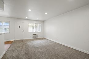 Anaheim apartment for rent - A room with a carpeted floor and a window with blinds.