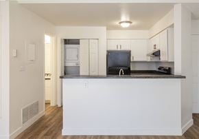 Colorado Springs apartment for rent - A kitchen with white cabinets and a black countertop.