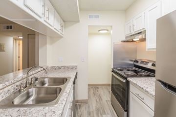 Colorado Springs apartment for rent - A kitchen with a stainless steel sink and white cabinets.