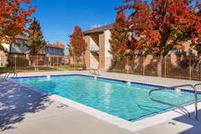 Taylorsville apartment for rent - A small pool surrounded by a fence with trees in the background.