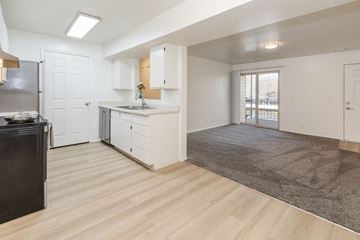 Taylorsville apartment for rent - A kitchen with white cabinets and a black fridge.