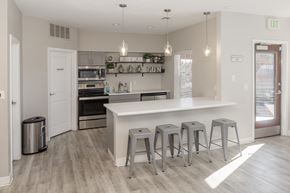 Aurora apartment for rent - A kitchen with a white counter and grey stools.