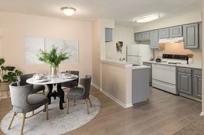 Aurora apartment for rent - A dining room with a white table and grey chairs.