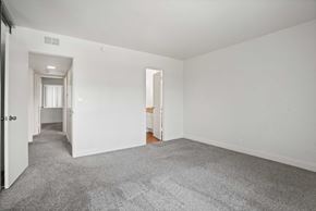 Anaheim apartment for rent - A spacious room with a carpeted floor and white walls.