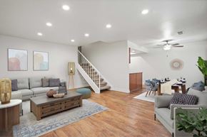 Anaheim apartment for rent - A living room with a staircase and a dining area.