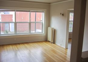 Portland apartment for rent - an empty living room with wooden floors and white walls