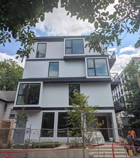 Portland apartment for rent - A modern house under construction with white siding and large windows.