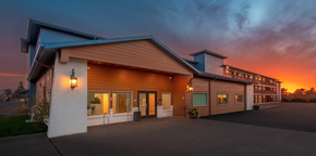 Seaside apartment for rent - A building with a sunset in the background.