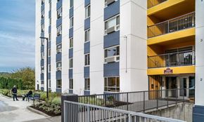 Milwaukie apartment for rent - a large building with many balconies and people sitting on benches