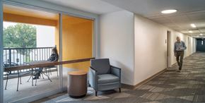 Milwaukie apartment for rent - a man walking down a hallway in a room with a table and chairs