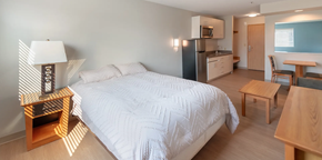 Seaside apartment for rent - A bedroom with a bed, a table, and a chair.
