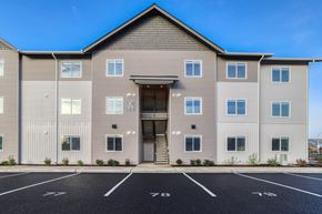 Vancouver apartment for rent - A large building with a parking lot in front of it.
