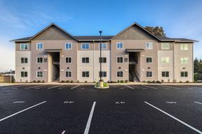 Vancouver apartment for rent - A large building with a parking lot in front of it.