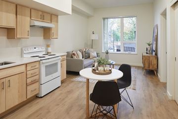 Milwaukie apartment for rent - A kitchen with a white stove top oven and a white microwave.