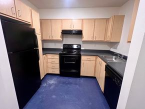 Vancouver apartment for rent - A kitchen with black appliances and wooden cabinets.