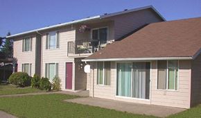 Portland apartment for rent - A building with a red door and a balcony with flowers.
