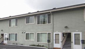 Portland apartment for rent - A grey building with white doors and windows.