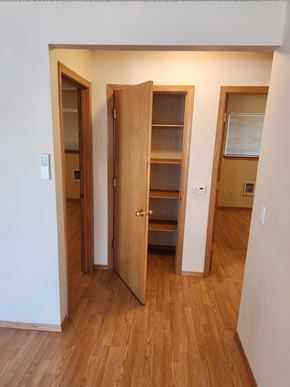 Portland apartment for rent - A room with a wooden floor and a white wall with a door open.