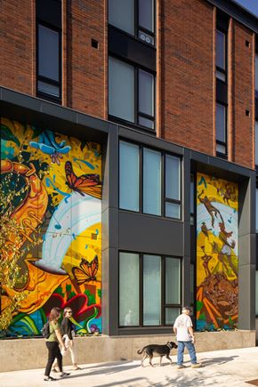 Portland apartment for rent - people walking on the sidewalk in front of a building with a mural