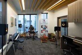 Portland apartment for rent - a man playing a guitar in a room with musical equipment
