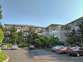 Portland apartment for rent - A parking lot in front of a building with cars parked.