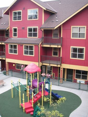 Portland apartment for rent - A red building with a playground in front.