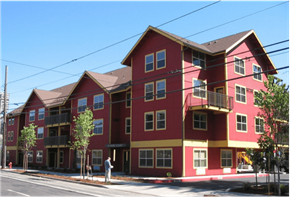 Portland apartment for rent - A red and yellow building with a person standing in front.