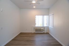 Tigard apartment for rent - an empty living room with a ceiling fan and a window