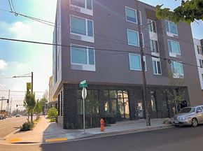 Portland apartment for rent - A modern building with a grey facade and a street in front.