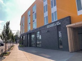 Portland apartment for rent - A modern building with the sign "Orchards of 82ND" on its facade.